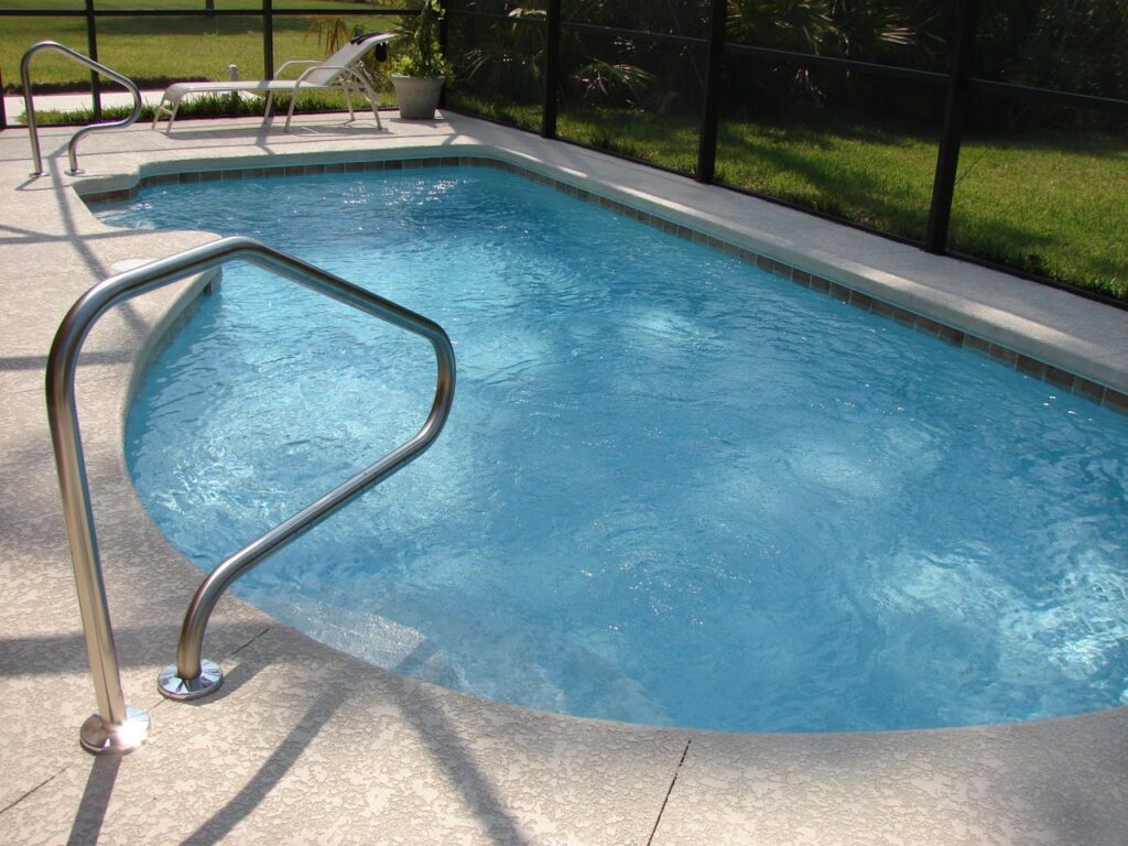 A tranquil image of a clean swimming pool set in a sunny backyard, perfect for relaxation.